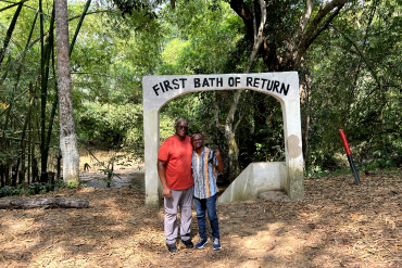 Two men standing in front of first bath of return inscription