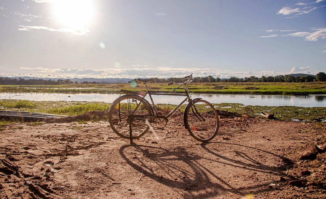 A bicycle on a dirt path next to a river in Maamba, Zambia