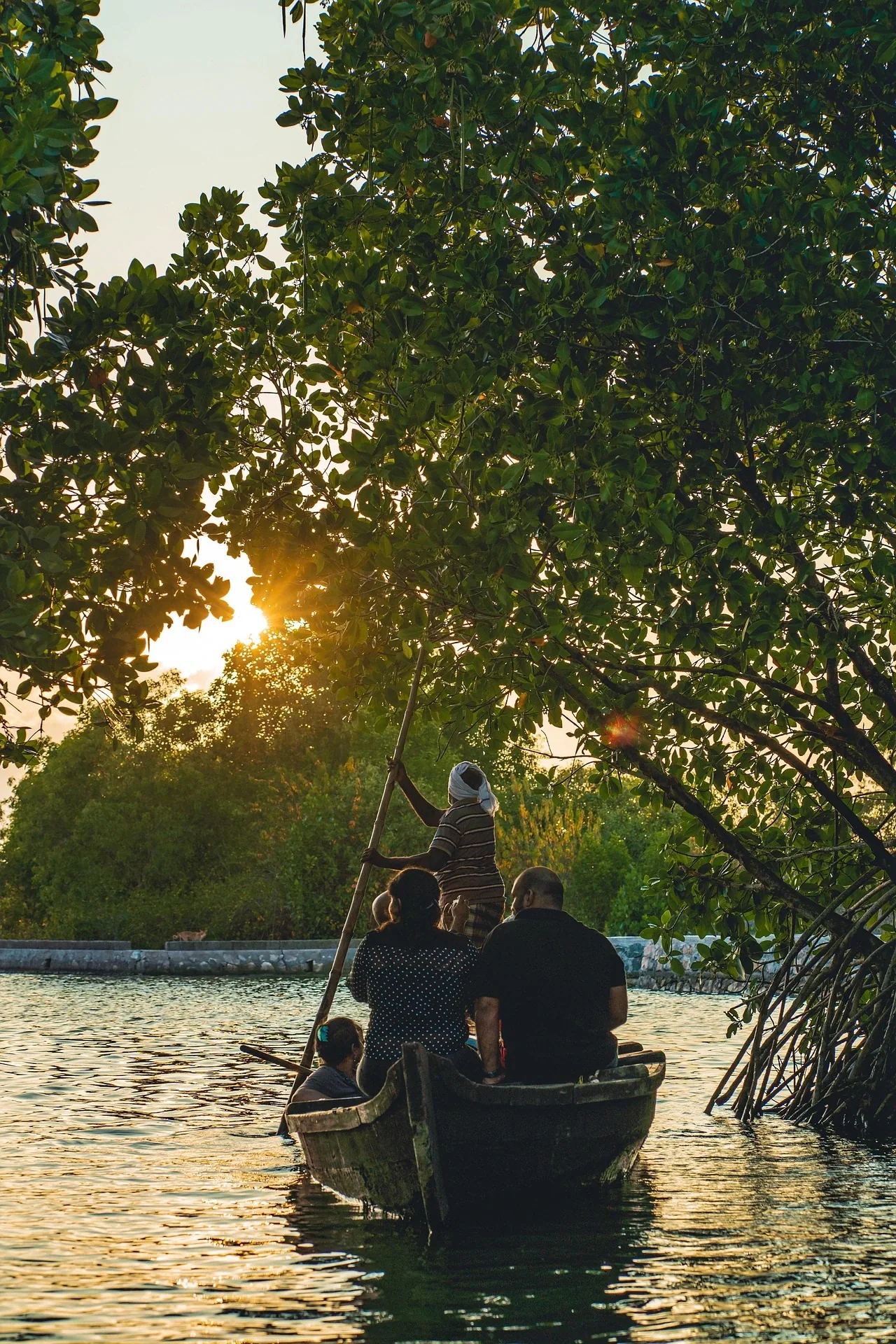 Group of people on a canoe tour in the backwaters of Munroe Island, India