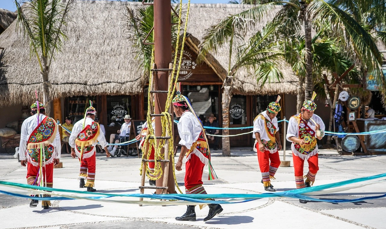 Five men in traditional, colourful folk costumes dancing in Costa Maya