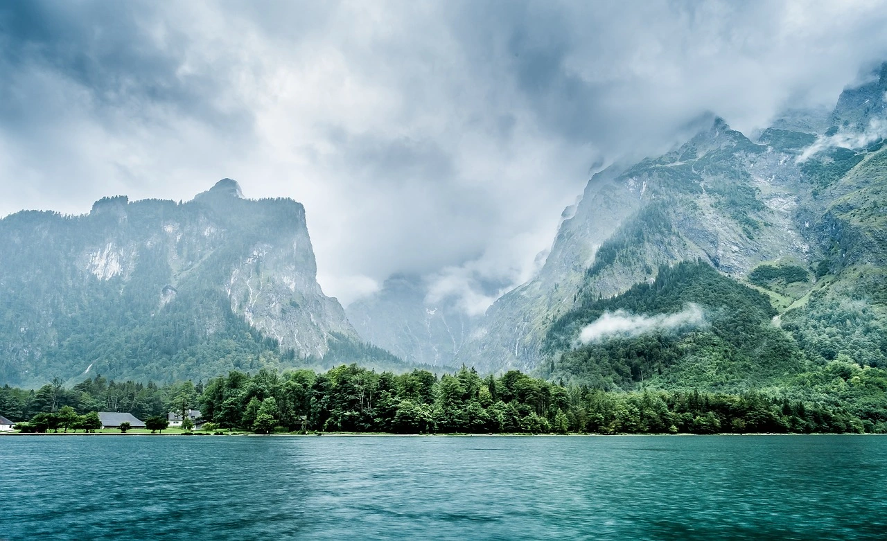 Misty mountains rising above a blue lake