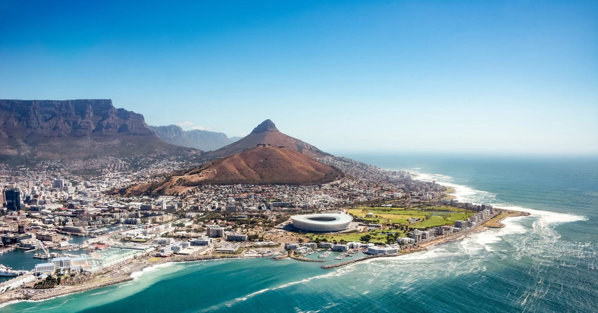 Aerial view of Cape Town with Table Mountain and Lion's Head above the city and the Atlantic coastline.