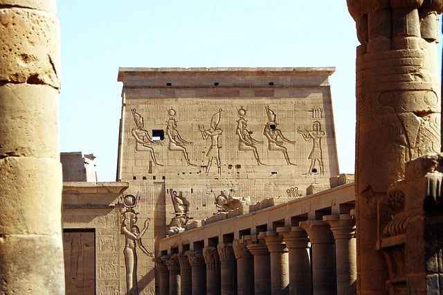 An ancient Egyptian temple complex with towering columns and carved reliefs, representing Egypt's pharaonic architectural legacy