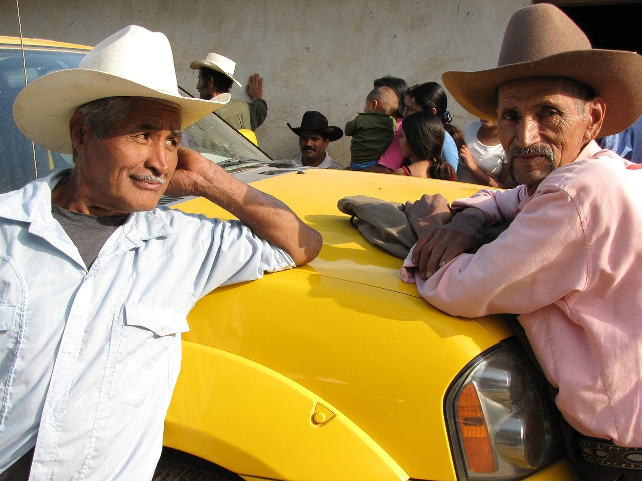 Two men wearing cowboy hats in Garifuna Village during a cultural journey