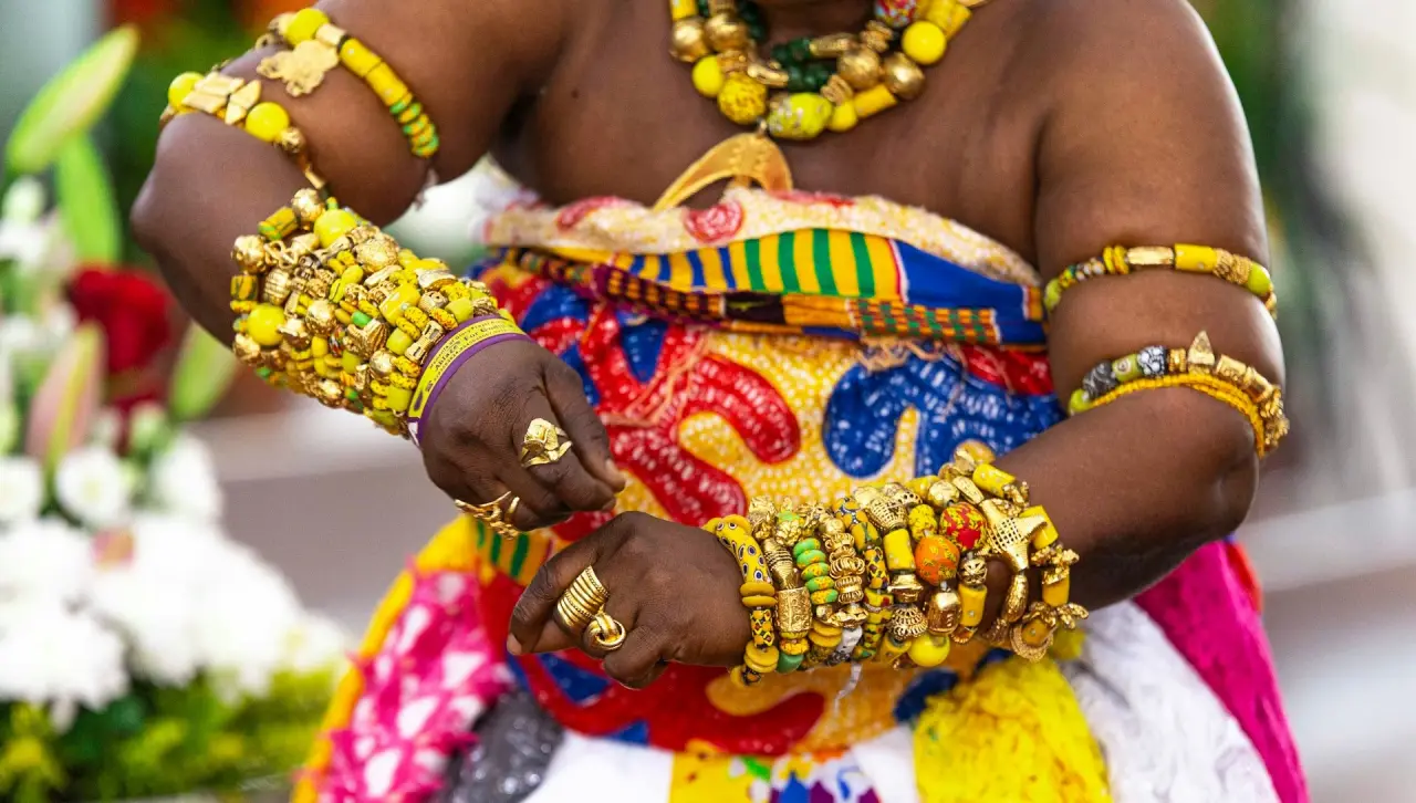 A woman dancing adowa in a traditional kente outfit in ghana during a cultural journey