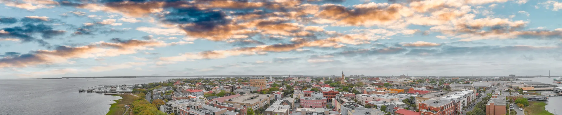 Aerial panoramic view of Charleston South Carolina waterfront skyline at sunset with historic church steeples and harbor