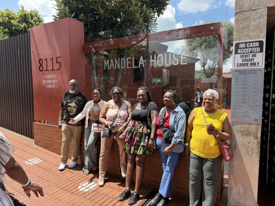 Group of six visitors posing at Mandela House; 8115 Vilakazi St; Orlando West; Soweto; during eat-mea-2026 tour.