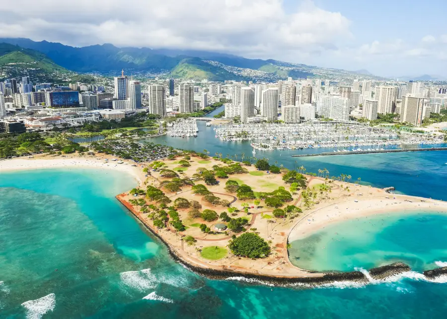 Aerial view of Honolulu harbor marina and Magic Island park; ideal backdrop for group cruises departing Waikiki.
