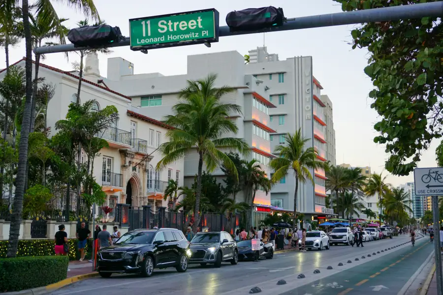 Ocean Drive at 11th Street in Miami; Florida; showing Art Deco hotels; palm trees; and evening traffic.