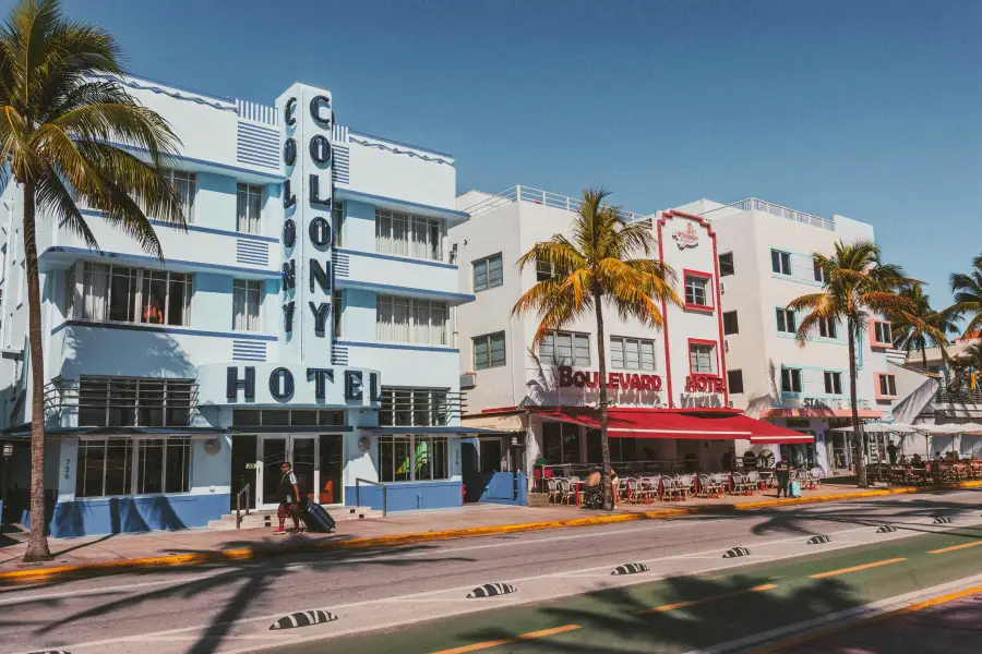 Art Deco Colony and Boulevard hotels line Ocean Drive in Miami Florida under clear blue skies with palm trees.