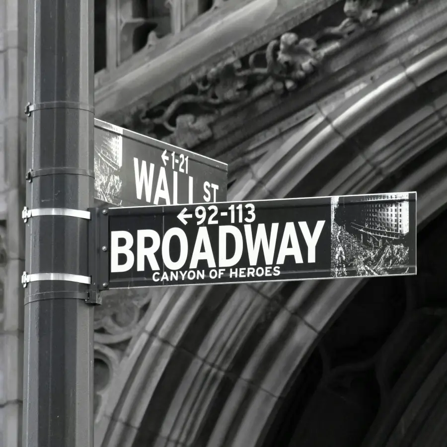 Street signs marking Broadway Canyon of Heroes and Wall St intersection in Lower Manhattan New York New York in black and white photograph