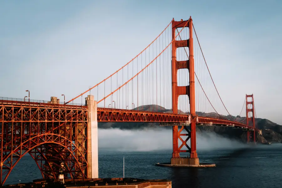 Golden Gate Bridge in san-francisco-ca with low fog rolling across the bay beneath the iconic red suspension towers.
