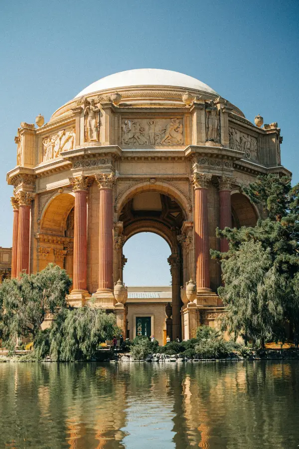 Palace of Fine Arts rotunda with Roman columns and dome reflected in lagoon; San Francisco; CA on a clear sunny day.