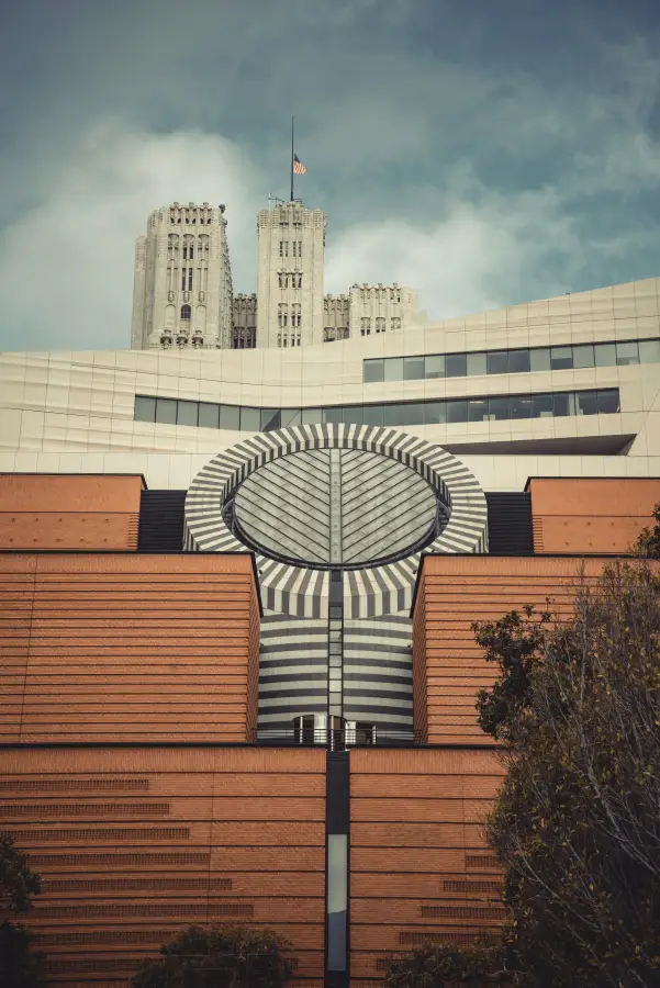 SFMOMA's striped cylindrical skylight rises above red brick facade with Gothic towers of a historic san-francisco-ca build...