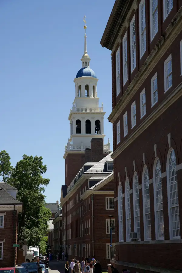 Independence Hall tower with white steeple rising above brick buildings in Philadelphia.
