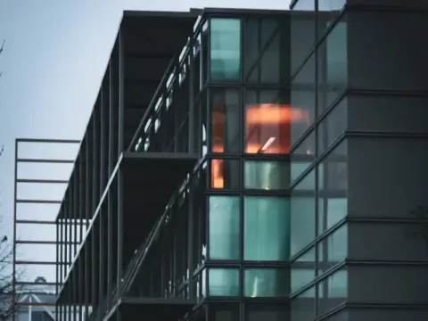 A contemporary glass building with illuminated interiors, showcasing modern architecture