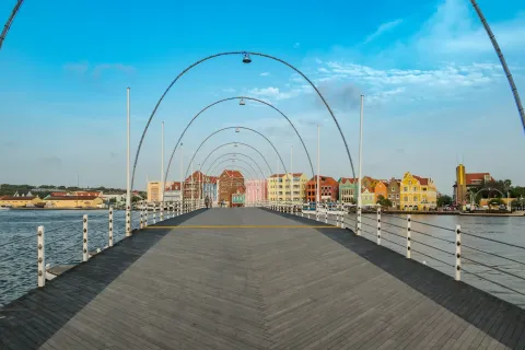 The Queen Emma pontoon bridge leading to the colored colonial facades of the Handelskade in Willemstad.