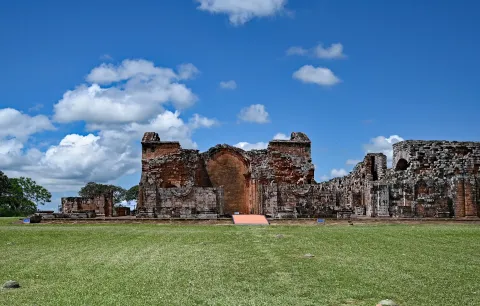 The red sandstone walls of the ruined mission church at La Santisima Trinidad de Parana in Paraguay, on open grass