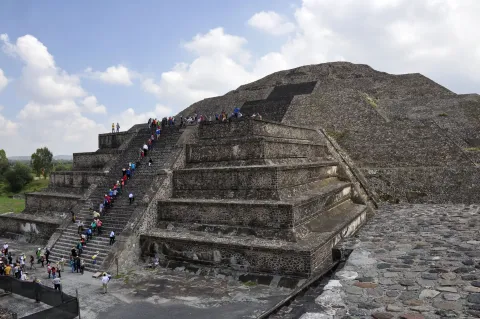The stepped stone terraces of the Pyramid of the Moon at Teotihuacan in Mexico, visitors climbing the central stairway