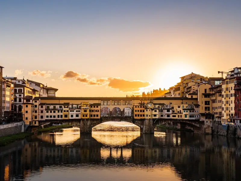 The Ponte Vecchio and its shops reflected in the Arno at sunset, Florence
