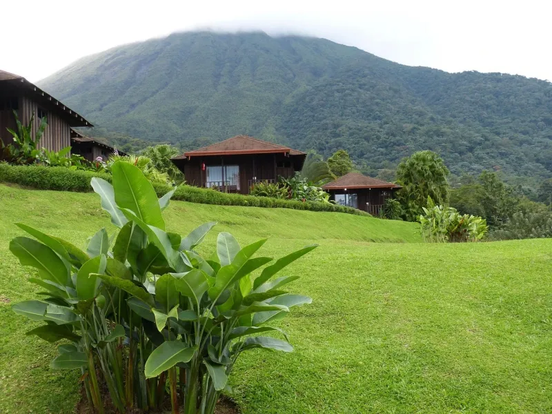 Lodge grounds and lawns below the forested cone of Arenal Volcano in Costa Rica.