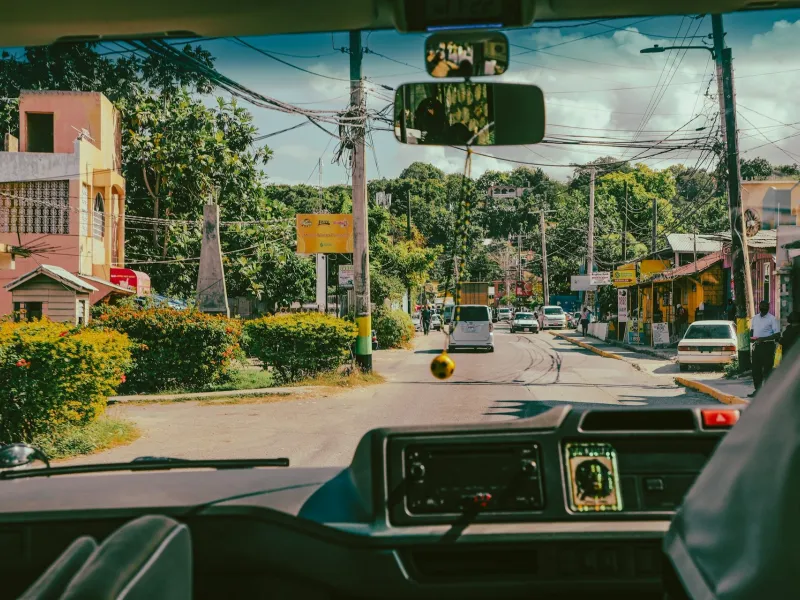 Vehicle traveling down a street in Jamaica for a destination guide