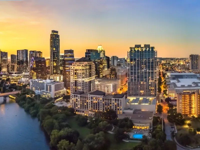 Aerial panoramic view of Austin Texas downtown skyline at sunset with the Colorado River and glowing city lights