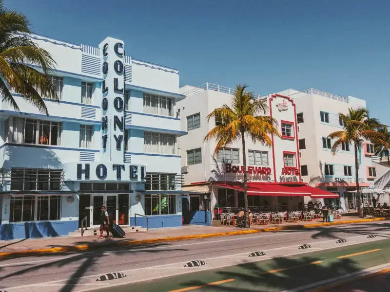 Art Deco Colony and Boulevard hotels line Ocean Drive in Miami Florida under clear blue skies with palm trees.