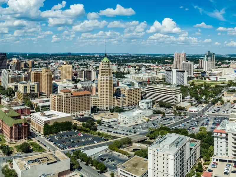 Aerial panoramic view of San Antonio Texas downtown skyline with Tower of the Americas and historic buildings under blue sky