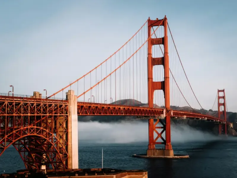 Golden Gate Bridge in san-francisco-ca with low fog rolling across the bay beneath the iconic red suspension towers.