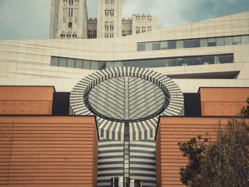 SFMOMA's striped cylindrical skylight rises above red brick facade with Gothic towers of a historic san-francisco-ca build