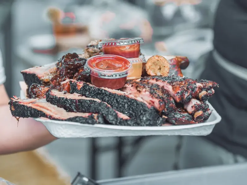 Tray of smoked barbecue ribs and brisket with sauces, a classic American regional cuisine