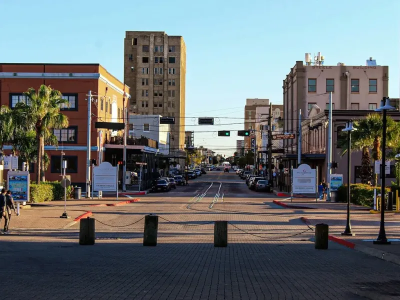 The historic Strand district in Galveston, Texas with brick streets, palm trees, and 19th-century commercial buildings