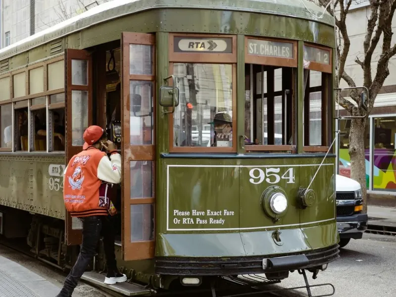 The historic green St. Charles Avenue streetcar picking up a passenger in New Orleans