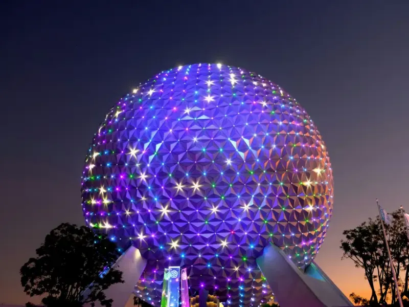 Spaceship Earth geodesic sphere at EPCOT illuminated with colorful LED lights at dusk in Orlando; FL.