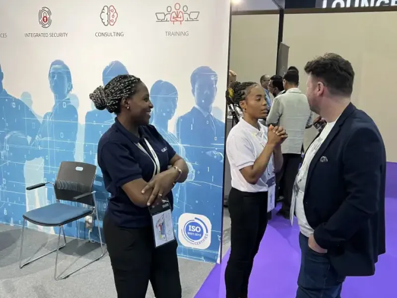 Three professionals networking at the LABUSA USA booth at Intersec; discussing integrated security and consulting services.