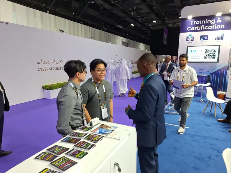 LABUSA Training & Certification booth at Intersec expo with attendees discussing cybersecurity programs in Dubai.