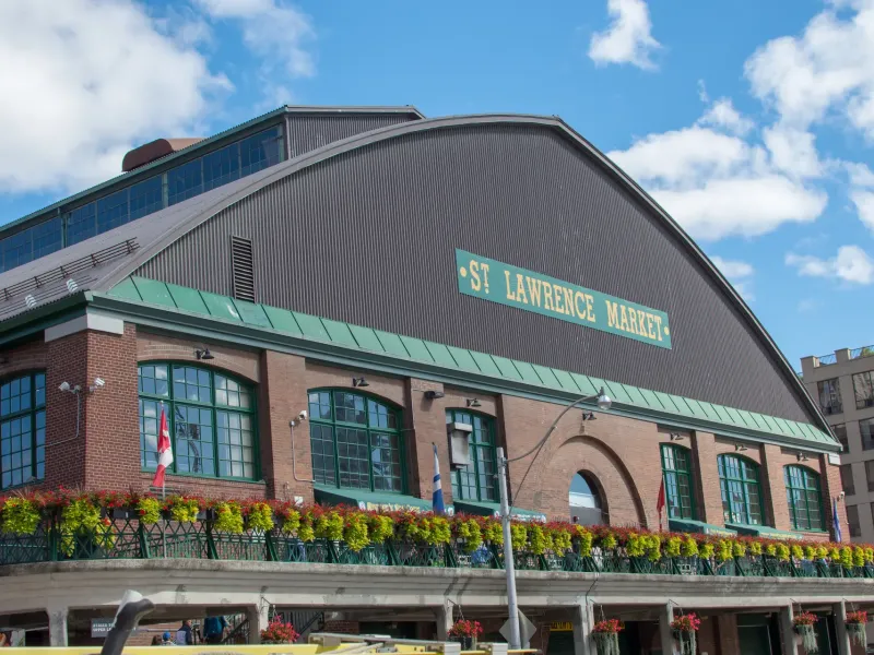 The brick and green trimmed market hall with its name lettered on the curved roof and flower boxes along the terrace.