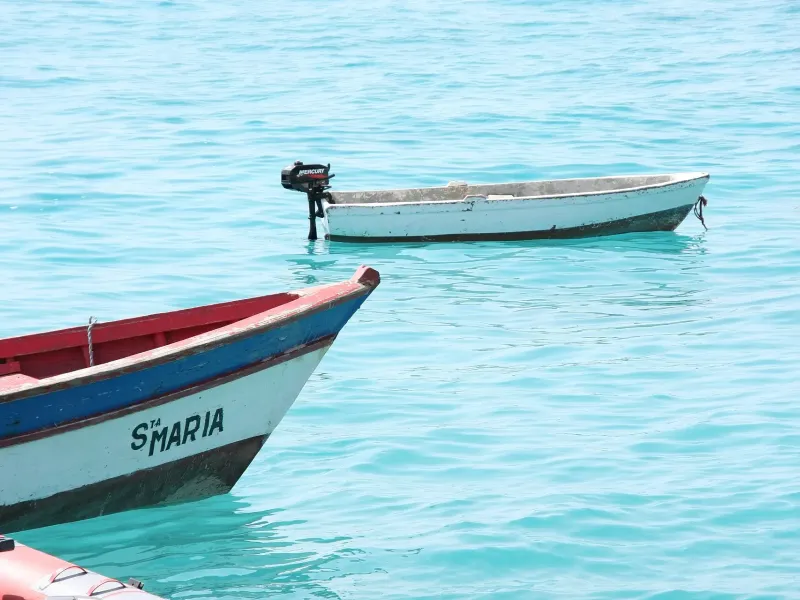 Two painted fishing boats on clear turquoise water off Santa Maria on the island of Sal.