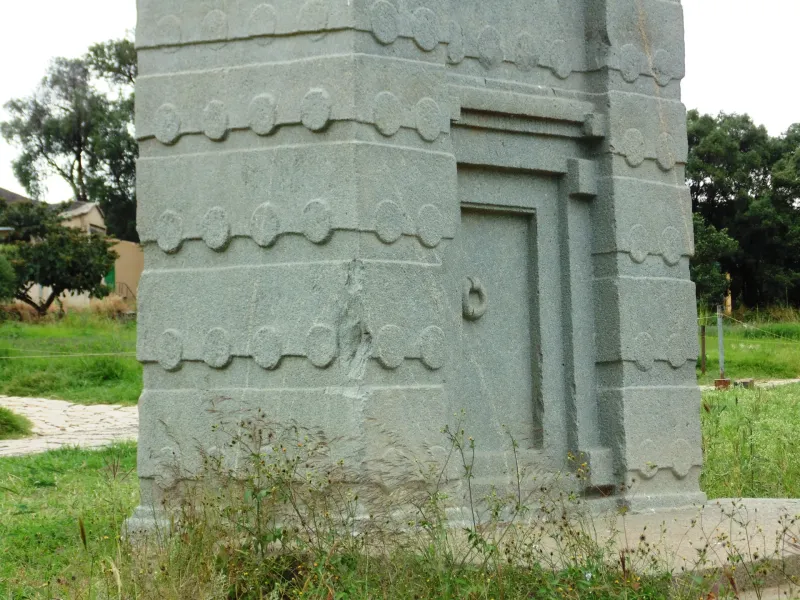 The base of a carved granite stele at Aksum, Ethiopia, worked with story lines, beam ends and a false door at its foot.