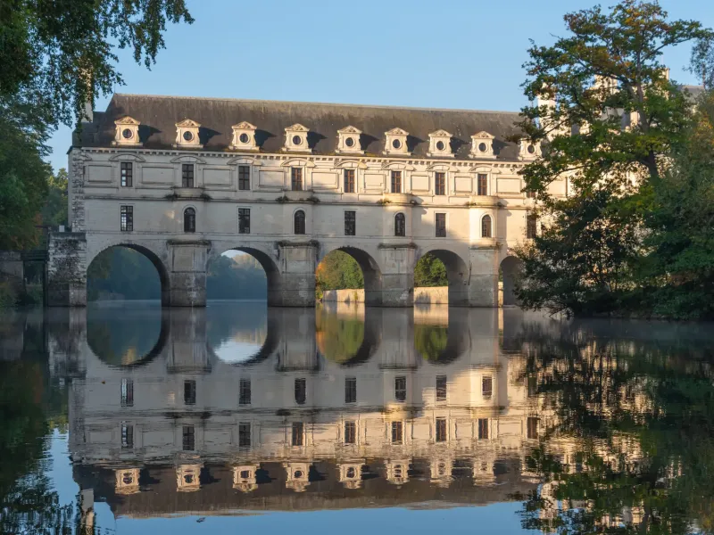 The gallery of the Chateau de Chenonceau carried on arches across the river Cher and reflected in the still water.