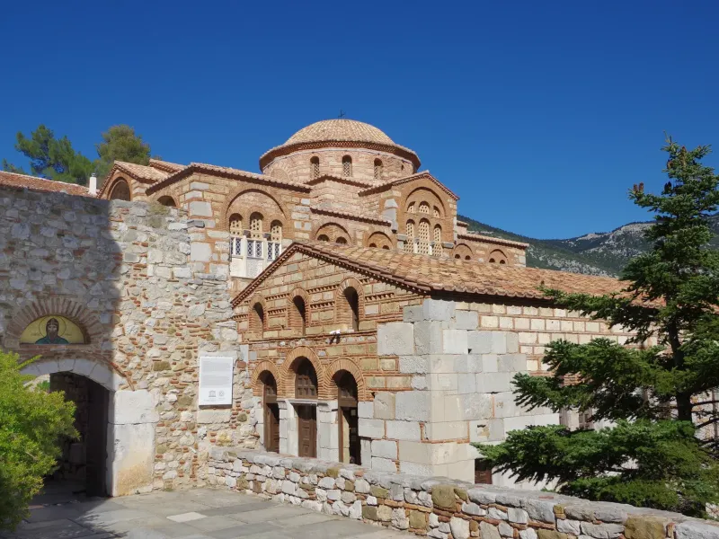 The brick and stone Byzantine church of the Hosios Loukas monastery in Boeotia, Greece, with its tiled dome.