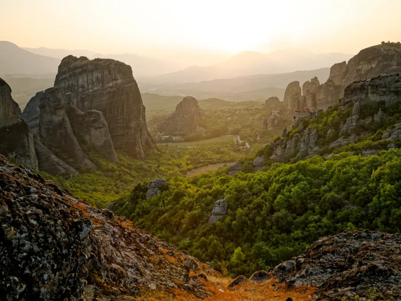 Monasteries perched on the sandstone pillars of Meteora in Thessaly, Greece, in low evening light.