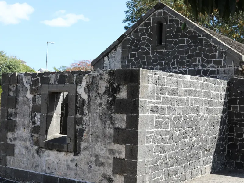 Basalt block walls and a stone building surviving from the immigration depot at Aapravasi Ghat in Port Louis, Mauritius.