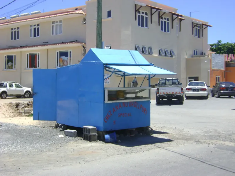 A blue street-food cart of the kind dholl puri is sold from, parked on a road in Mauritius.