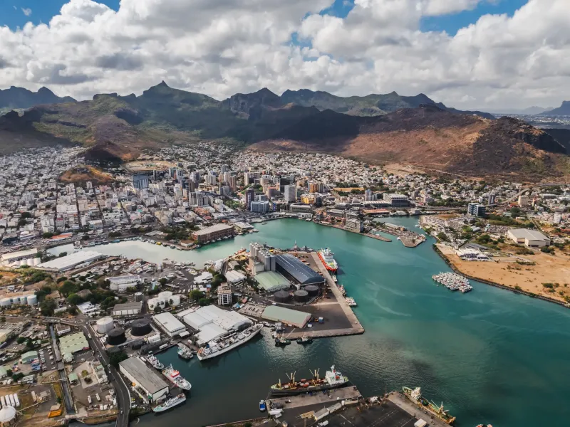 The city of Port Louis and its working harbor seen from above, the Moka range rising behind.