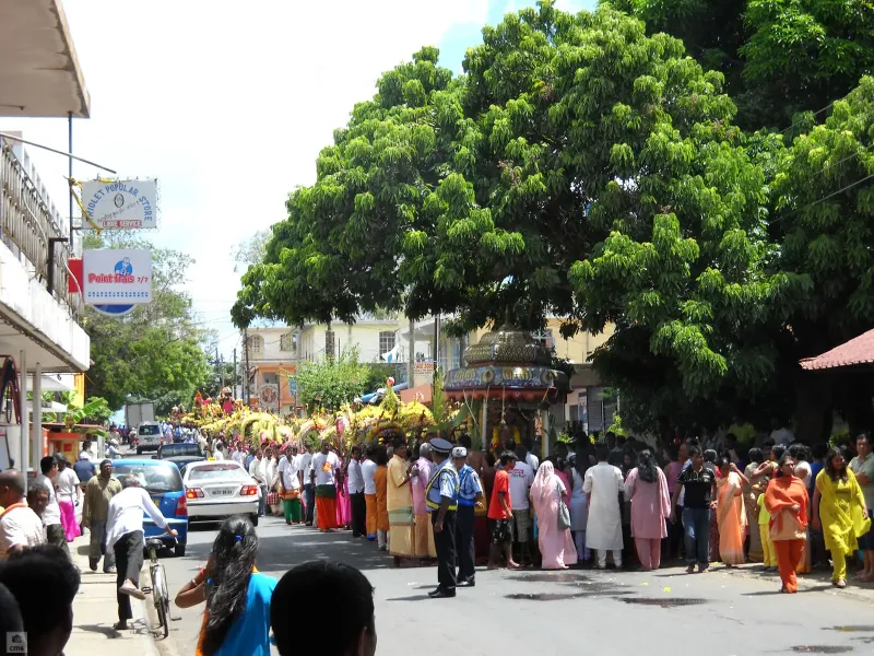 A Thaipoosam Cavadee street procession in Mauritius, a decorated kavadi carried along a road lined with onlookers.