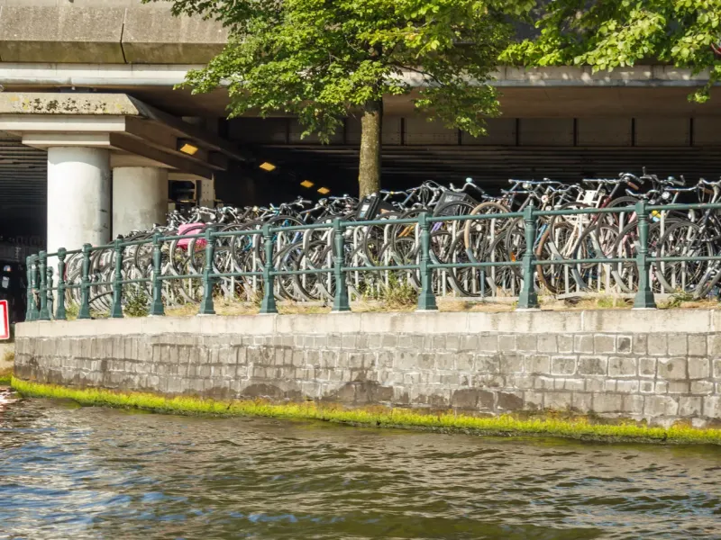 Hundreds of bicycles racked along a multi-level parking deck built out over the water at Amsterdam's Stationsplein.