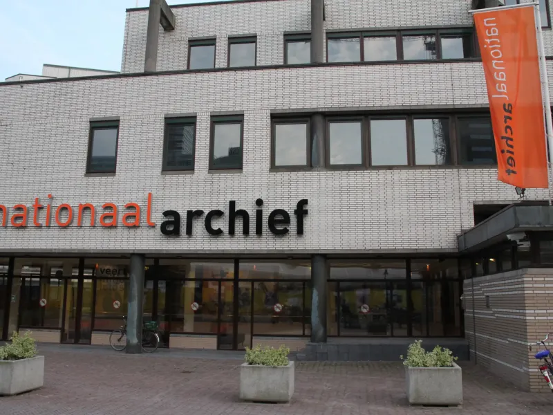 The entrance of the Nationaal Archief in The Hague, its name across the facade and orange banners beside the doors.