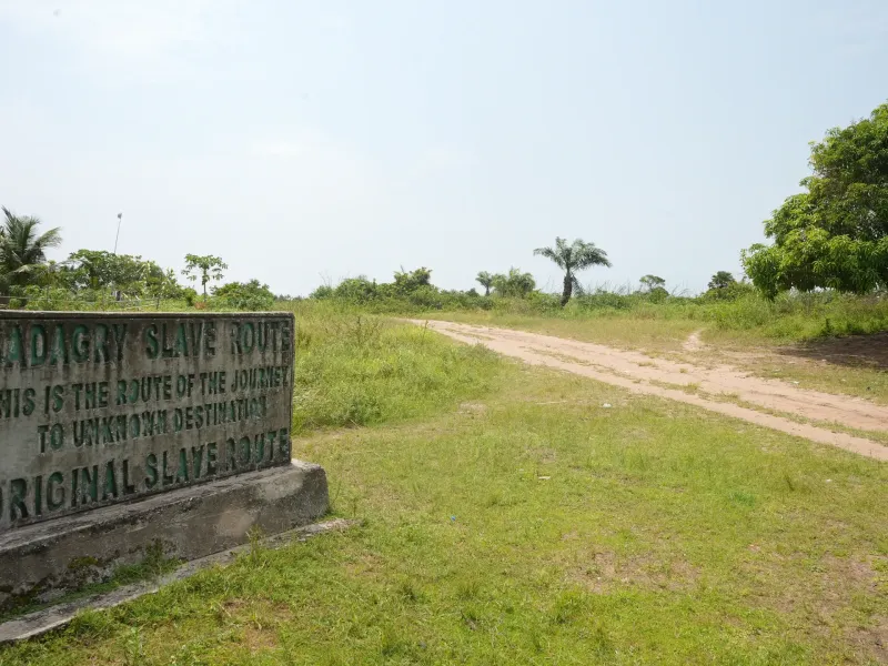 Marker beside the sand track at Badagry: Badagry Slave Route, this is the route of the journey to unknown destination.